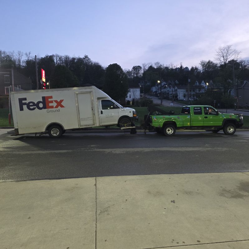 Tow truck assisting a stranded car on highway